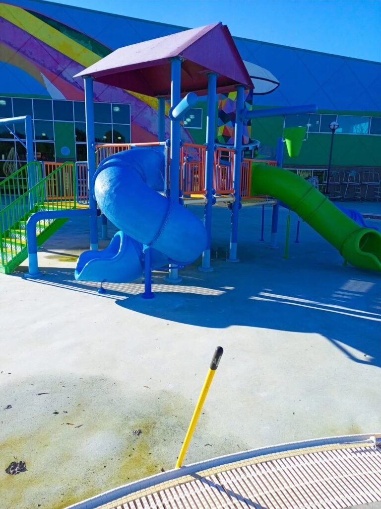 Renovated Manchester, TN water park playground with blue and green slides.